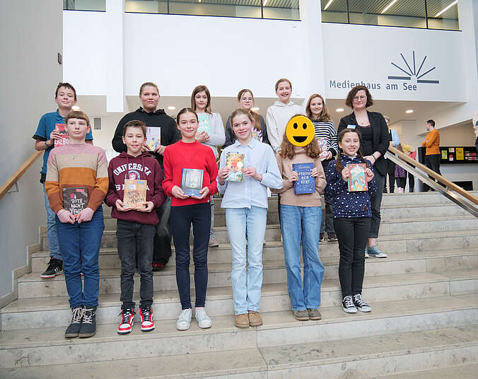 Gruppenbild der Teilnehmer und Teilnehmerinnen des Lesewettbewerbs zusammen mit Kinder- und Jugendbibliothekarin Alexandra Schenk