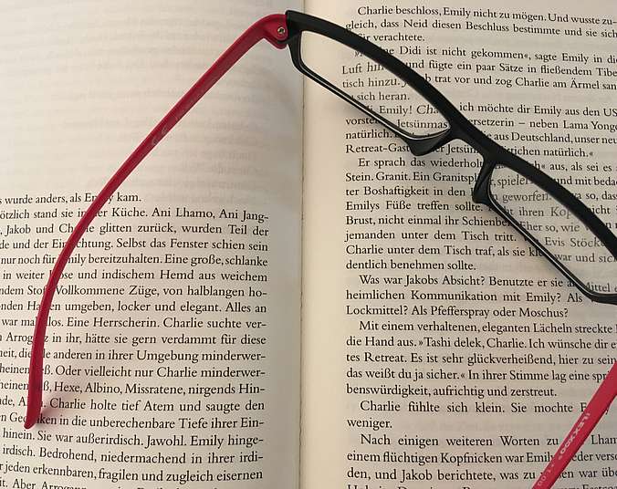 Brille liegt auf einem Buch