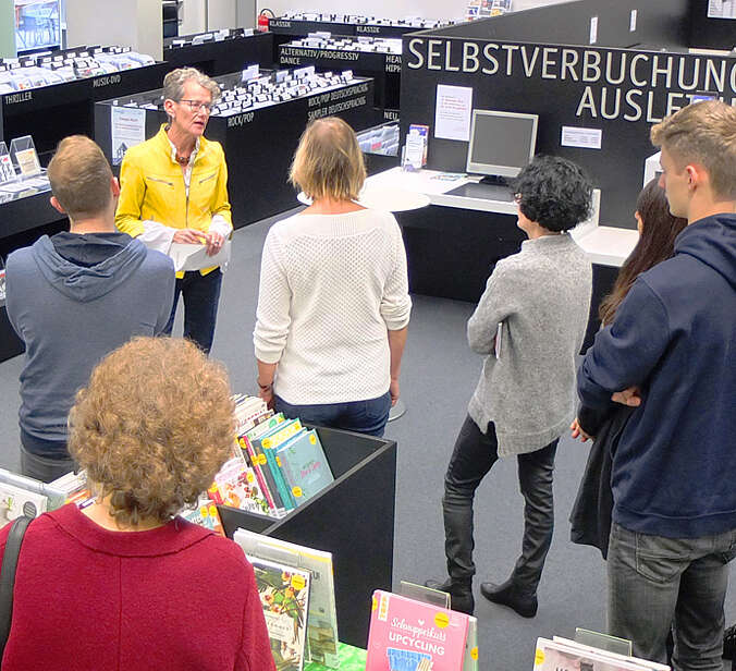 Gruppe hört bei Führung in Bibliothek zu