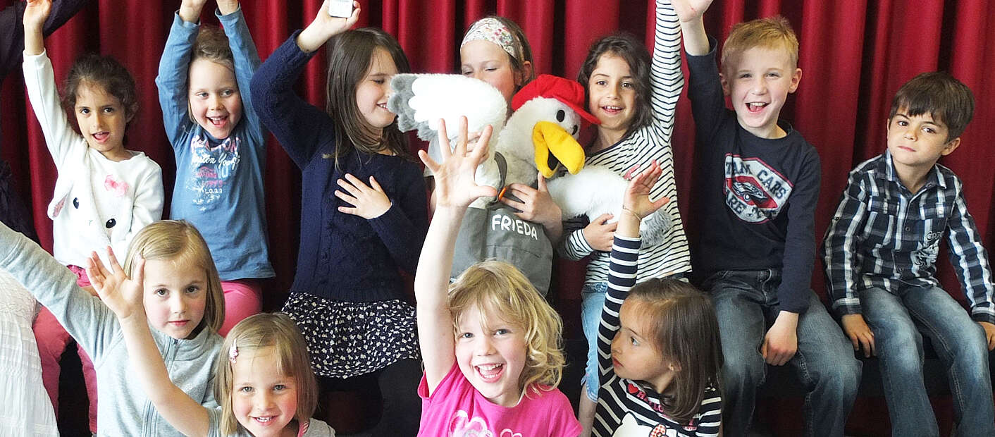 Kinder mit erhobenen Armen lachen