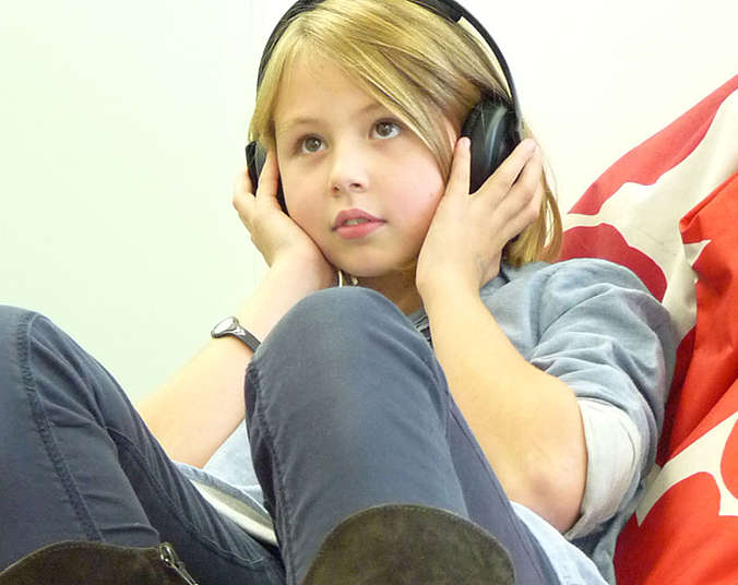 Mädchen auf Sitzsack mit Kopfhörern