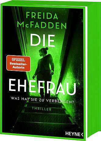 Eine Frau am oberen Absatz einer Treppe die sich nach hinten umsieht.