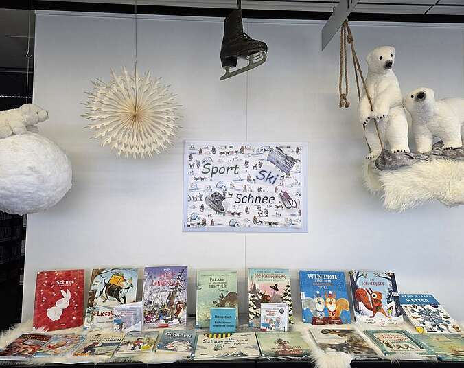 Ausstellung mit Büchern auf einem Tisch und darüber Deko passend zum Thema