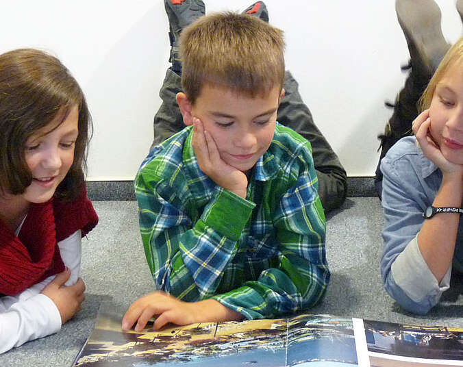 Drei Kinder lesen ein Buch