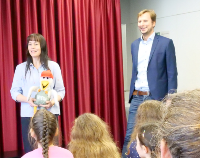 Bürgermeister Andreas Hein und Jutta Kubalczyk mit Frieda vom Medienhaus vor einer Klasse
