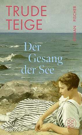 Ein Frau am felsigen Strand liegend bei rauer See.